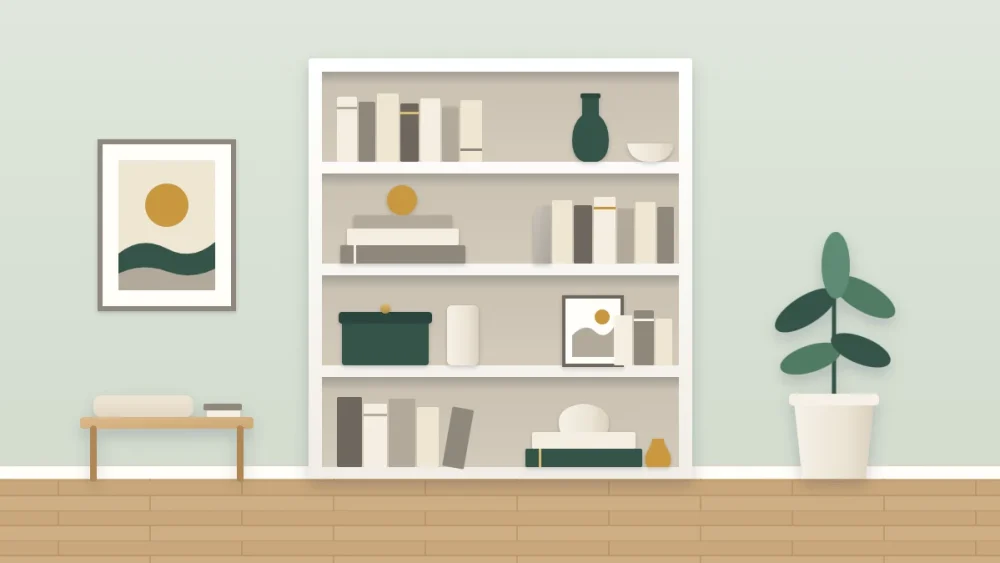 White bookcase styled with cream and warm gray books and ceramics, deep green repeated in three objects and ochre in three small accents